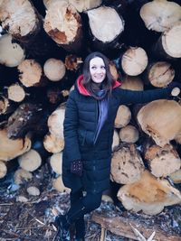 Young woman standing by log