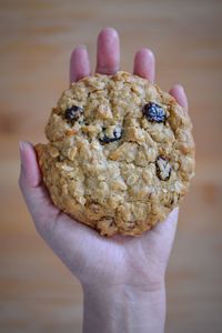 Cropped hand of woman holding cookie at home 