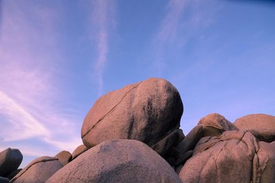 Low angle view of rocks against blue sky