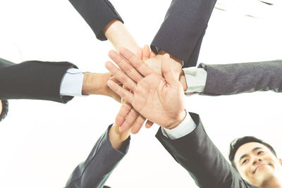 Low angle view of people hands against clear sky