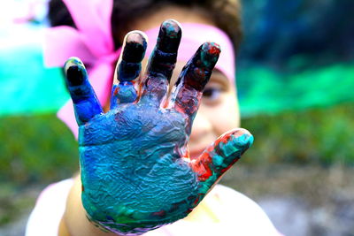 Cropped hand of girl with multi colored paint