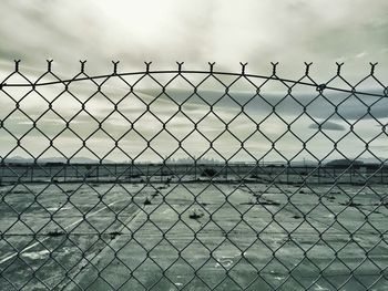 Close-up of chainlink fence against sky