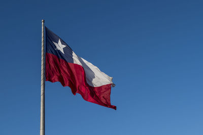 Low angle view of chile flag against clear blue sky