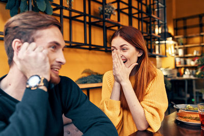 Portrait of young couple sitting in restaurant