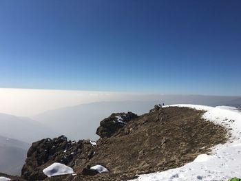 Scenic view of snowcapped mountains against clear blue sky