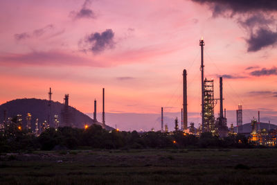 Electricity pylons against sky during sunset