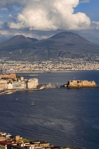 Aerial view of buildings by sea against sky