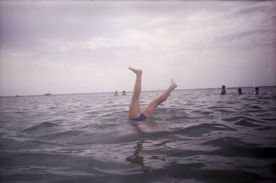 Man surfing in sea against sky