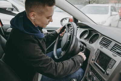 Side view of young man in car