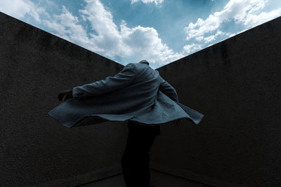 Low section of woman standing against wall