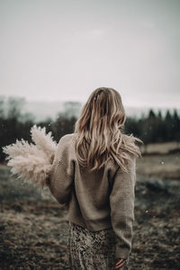 Rear view of woman standing against sky