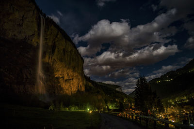 Panoramic view of road by mountains against sky at night