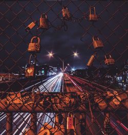 Illuminated railroad tracks against sky at night