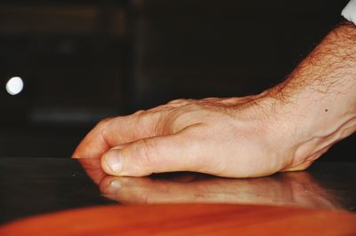 Close-up of hand touching table