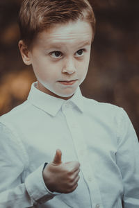 Boy gesturing while standing outdoors