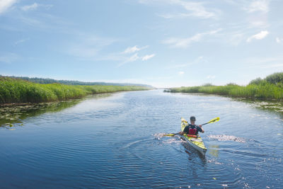 People enjoying in river against sky