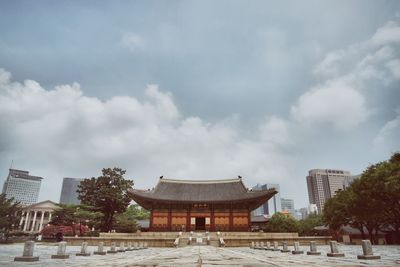 Facade of deoksugung palace against cloudy sky