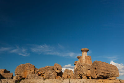 Rock formations on landscape against blue sky