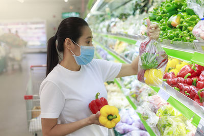 Midsection of woman holding ice cream in store