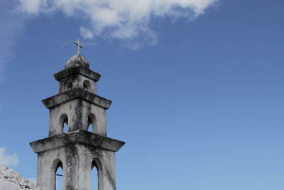 Low angle view of cross on building against sky