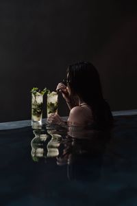 Young woman drinking juice in swimming pool