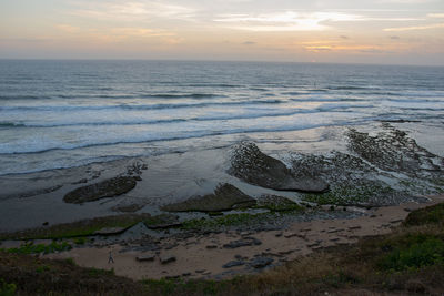 Scenic view of beach against sky during sunset