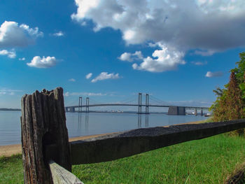 Bridge over river against cloudy sky