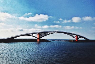 View of bridge over sea against cloudy sky