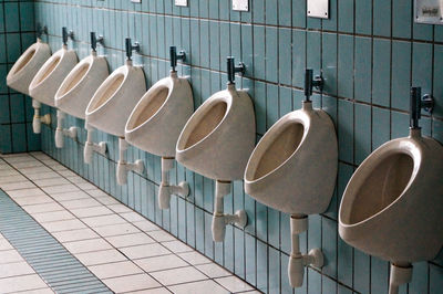 Empty seats in row on tiled floor against wall