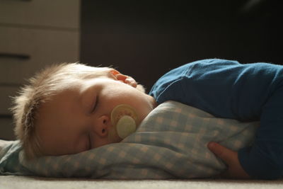 Close-up of baby sleeping in bed