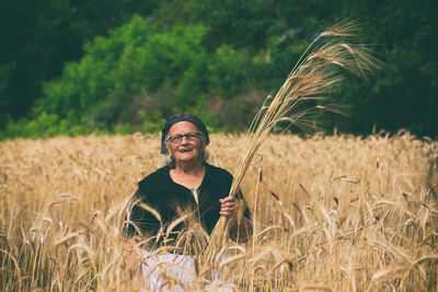 Smiling young woman standing in field