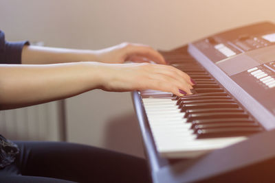 Cropped hands of woman playing piano