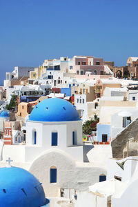 Buildings in town against clear blue sky