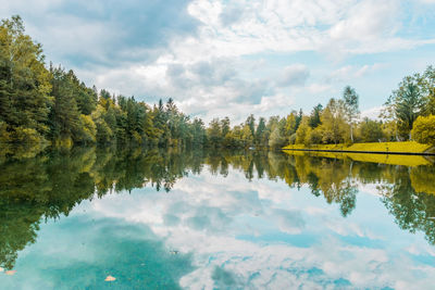 Scenic view of lake by trees against sky