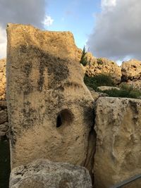 Low angle view of rock formation against sky