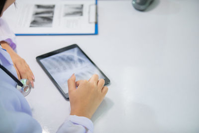 Midsection of person using laptop on table