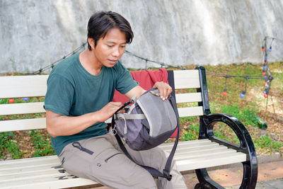 Young man sitting on bench