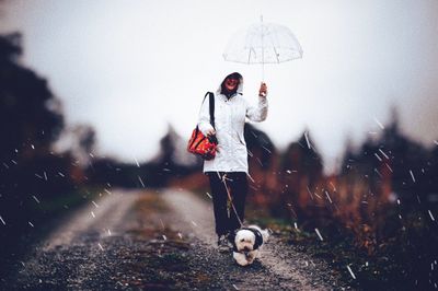 Woman standing on wet umbrella during rainy season