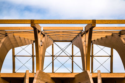 Detail of a modern wooden architecture in glued laminated timber on a blue cloudy sky