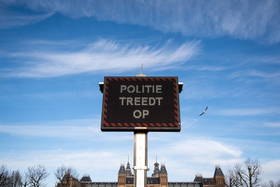 Low angle view of information sign against sky