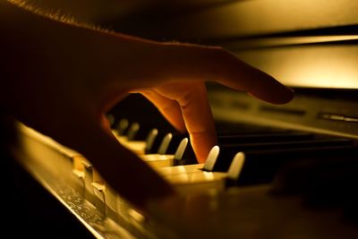 Cropped hand of person playing piano