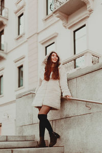 Full length of young woman standing outside building