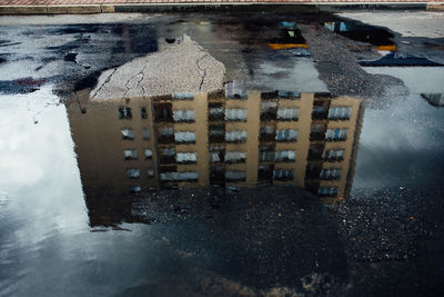 Reflection of city in puddle on road