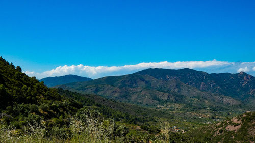 Scenic view of mountains against blue sky