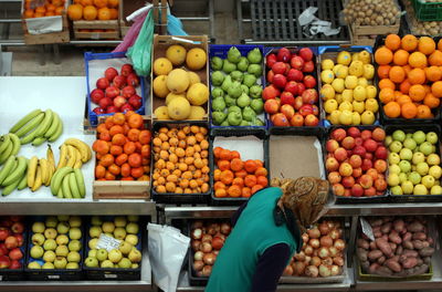 Woman against fruits in crates at market stall