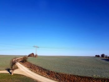 Scenic view of agricultural field against clear blue sky
