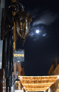 Low angle view of illuminated lighting equipment at night