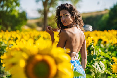 Woman standing on yellow flowering plants