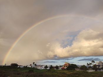 Scenic view of rainbow over landscape against sky