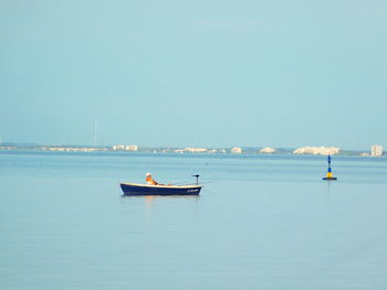 Boat moored on sea against clear sky